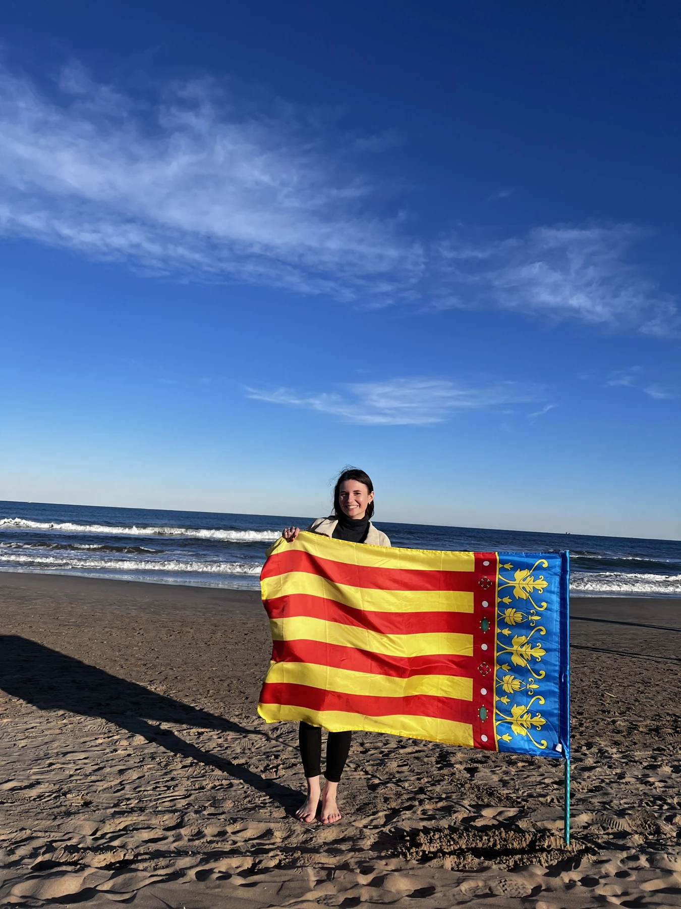 Założycielka Study Wild na plaży w Walencji z flagą Walencji